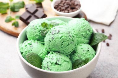 Gri masadaki kasede naneli çikolata parçacıklı dondurma, yakın plan.