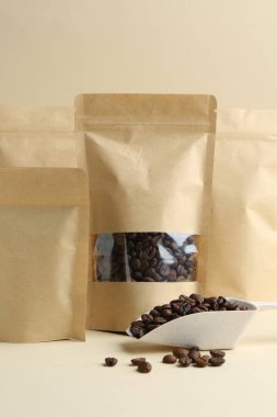 Bej arkaplanlı kahve çekirdekli stand-up torbaları, yakın plan.