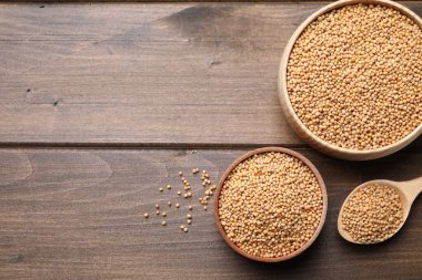 Hardal tohumları farklı bulaşık takımlarında, tahta masada, düz yerde. Metin için boşluk