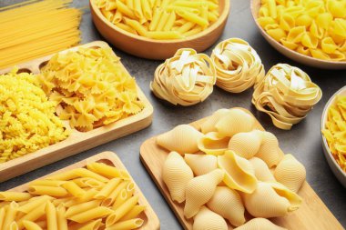 Gri masadaki farklı çiğ makarna türleri, yukarıdaki görünüm