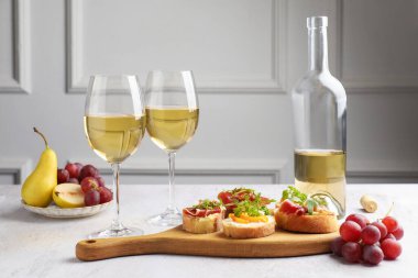 Beyaz masada servis edilen prosciutto ve şaraplı lezzetli bruschettalar.