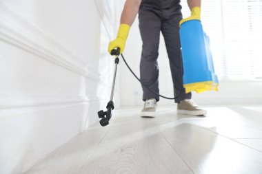 Böcek ilaçlama işçisi kapalı alanda böcek ilacı sıkıyor.