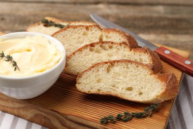 Tereyağlı baget dilimleri, kekik ve bıçak masada, yakın plan.