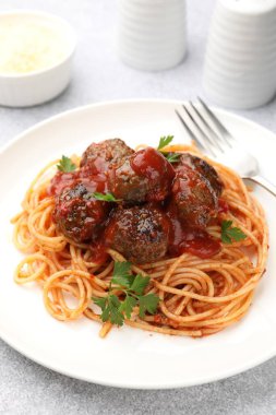 Açık gri masada servis edilen köfteli lezzetli makarna, yakın plan.