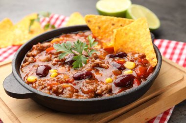 Gri masada nachos ve limonla servis edilen lezzetli biberli makarna, yakın plan.