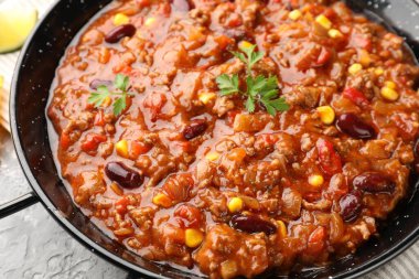 Lezzetli chili con carne servis edilmiş gri masa, yakın plan.