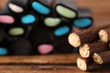 Doğal meyan kökü şekeri ve kökleri tahta masanın üzerinde, seçici bir odak noktası.