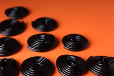 Turuncu arka planda doğal meyan kökü şekeri, yakın plan.