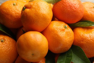 Taze mandalina ve yeşil yapraklar, yakın plan. Citrus meyvesi.