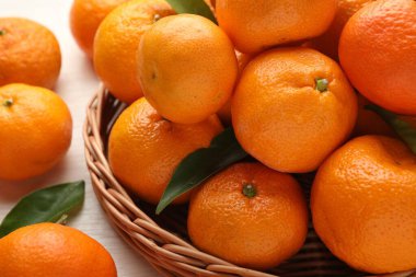 Taze mandalina ve yeşil yapraklar masada, yakın plan.