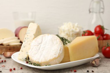 Gri masada servis edilen farklı taze süt ürünleri.