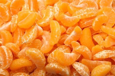 Arka plan olarak birçok olgun soyulmuş mandalina, üst görünüm