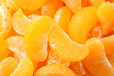 Arka plan olarak birçok olgun soyulmuş mandalina, üst görünüm