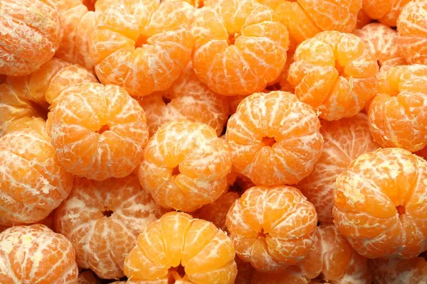 Arka plan olarak birçok olgun soyulmuş mandalina, üst görünüm