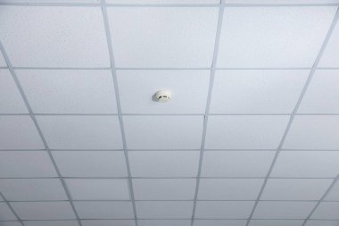 Kapalı tavan üzerindeki yangın alarmı, yakın plan.