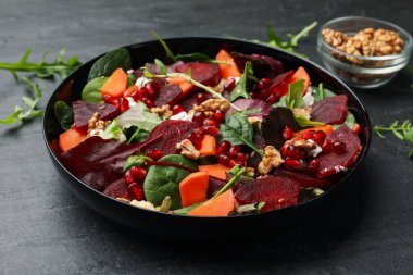 Pancar, ıspanak, roka, peynir, ceviz, havuç ve nar tohumlu nefis salata, yakın plan.