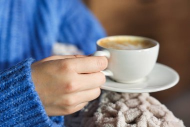 Kapalı mekanda bir fincan aromatik kahveli kadın, yakın plan.