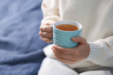 Kanepede sıcak çay içen bir kadın, yakın plan. Metin için boşluk