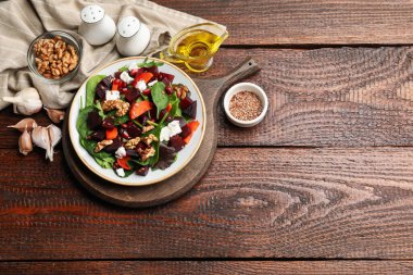 Pancar salatası, peynir, ıspanak, ceviz ve havuç, ahşap masada servis ediliyor. Metin için boşluk