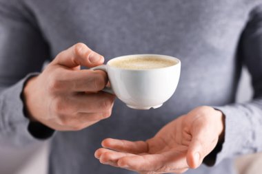 Kapalı mekanda bir fincan aromatik kahveli adam, yakın plan.