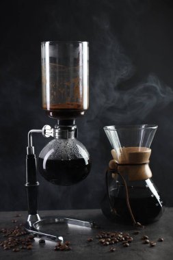 Sıcak içecek, fasulye ve cam kimya kahve makineli vakum kahve makinesi. Gri masada, yakın plan.