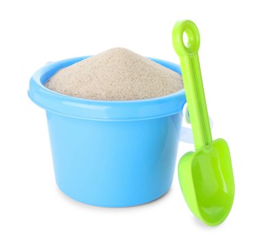 Beyaz üzerinde kum ve kürek olan plastik bir kova. Çocukların plaj oyuncakları.