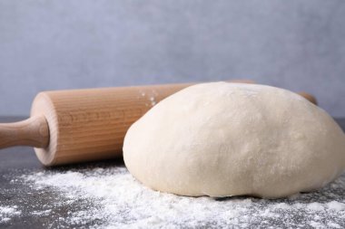 Hamur, merdane ve un gri masada, yakın plan.