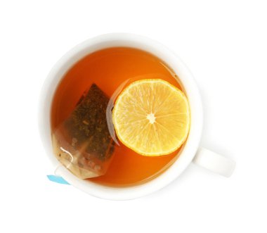 Beyaza izole edilmiş çay poşeti ve limonlu fincan, üst manzara. Aromatik çay demliyorum.