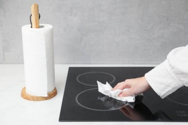 Mutfakta kağıt havluyla fırın temizleyen kadın, yakın plan.