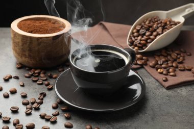 Kahve fincanda, fasulye de gri masada, yakın plan.