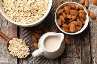 Yulaf gevreği, badem sütü ve fındıklar ahşap masada, düz yatıyordu.