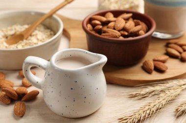 Yulaf gevreği, badem sütü ve açık ahşap masada fındık, yakın plan.