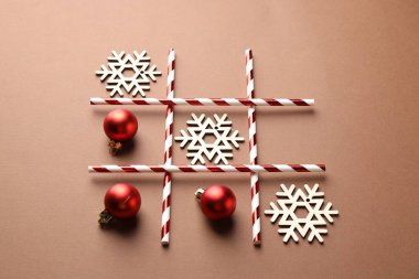 Bej arkaplanda takunya ve ahşap kar taneleriyle yapılan tik tak parmak oyunu