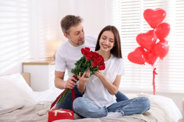 Adam içeride gül buketiyle kız arkadaşına sürpriz yapıyor. Sevgililer Günü kutlaması