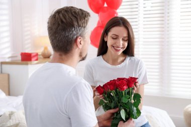 Adam içeride gül buketiyle kız arkadaşına sürpriz yapıyor. Sevgililer Günü kutlaması