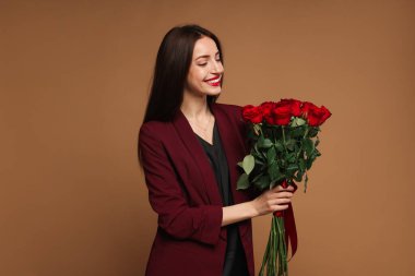 Sevgililer Günü. Bej arka planda gül buketi olan güzel bir kadın.