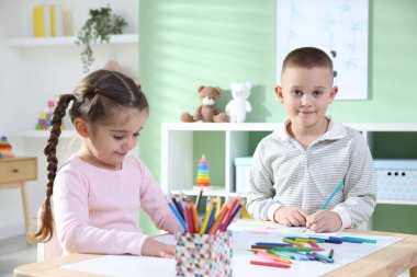 Çocuklar kalemle çizim yapıyorlar.