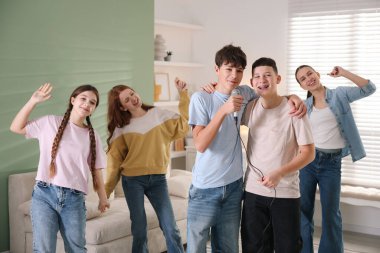 Genç arkadaşlar evde birlikte karaoke yapıyorlar.