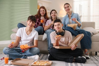 Bir grup arkadaş film izliyor ve evde atıştırmalık yiyor.