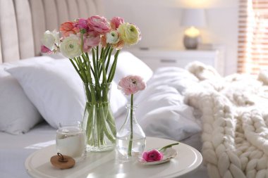 Yatak odasındaki masada güzel ranunculus çiçekleri, metin için yer