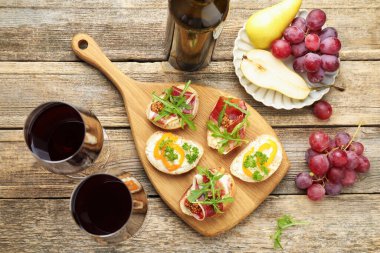 Prosciutto ve kırmızı şarap ile nefis bruschetalar ahşap masada servis edilir.