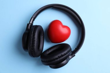 Açık mavi arka planda kulaklık ve kalp figürü, üst görünüm