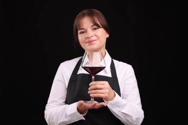 Siyah arka planda kırmızı şarap kadehi olan profesyonel şarap garsonu.