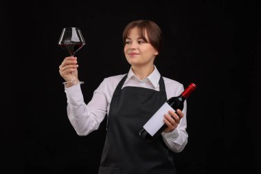 Siyah arka planda kırmızı şarap ve şişe olan profesyonel şarap garsonu.