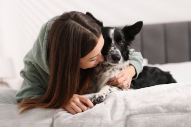 Evde yatağında Collie köpeği olan bir kadın.