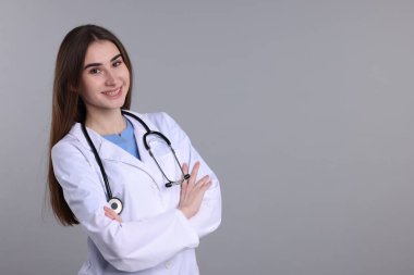 Gri arkaplanda tıbbi asistanın portresi, metin için boşluk