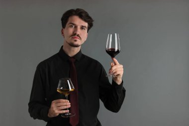 Gri arka planda şarap kadehleri olan profesyonel şarap garsonu.