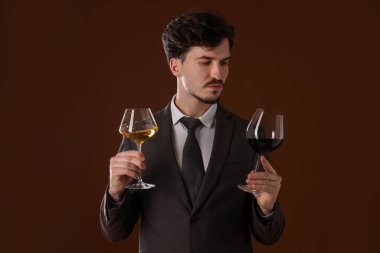 Kahverengi arka planda şarap kadehleri olan profesyonel şarap garsonu.