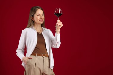 Kırmızı arka planda şarap kadehi olan profesyonel bir şarap garsonu. Metin için boşluk