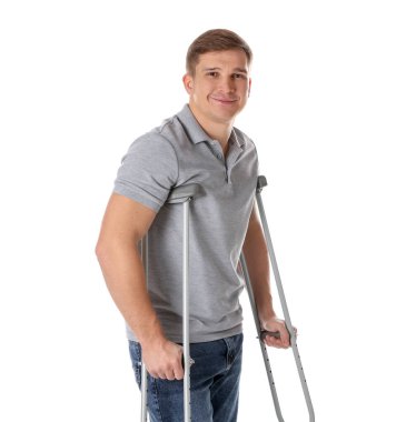 Beyaz arkaplanda koltuk değneği olan bir adam